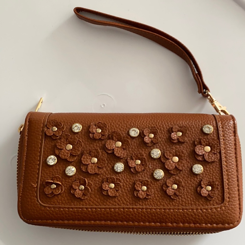 Under One Sky wristlet 8”x4”x1.5”. Caramel brown with floral embellishments.